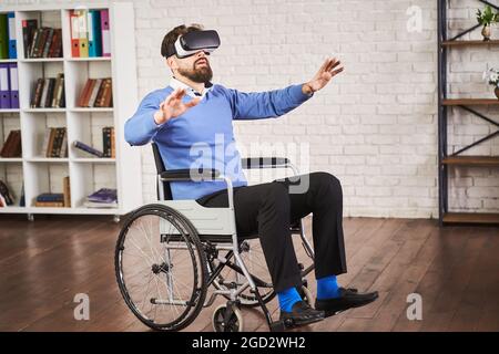 Man sitting in a wheelchair and using a VR headset Stock Photo