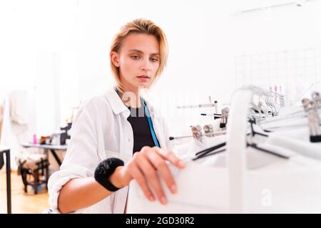 Fashion designer working in a clothing start-up workshop - Clothing tailor working on a new collection Stock Photo