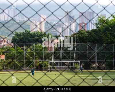 Medellin, Colombia - July 30 2021: Two Young Latinos Training Soccer with Several Balls on a Sunny Day Stock Photo