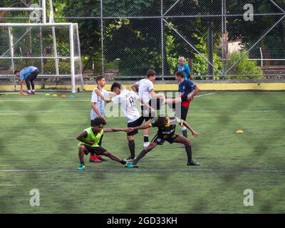 Medellin, Colombia - July 30 2021: Young Teenagers in Sportswear are Warming up on a Large Green Synthetic Field Stock Photo