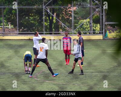 Medellin, Colombia - July 30 2021: Young Teenagers in Sportswear are Warming up on a Large Green Synthetic Field Stock Photo