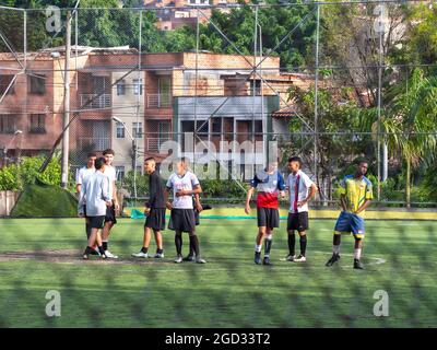 Medellin, Colombia - July 30 2021: Young Teenagers in Sportswear are Warming up on a Large Green Synthetic Field Stock Photo