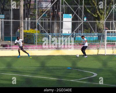 Medellin, Colombia - July 30 2021: Two Young Latin Teenagers in Sportswear Training Soccer with Several Balls on a Sunny Day Stock Photo