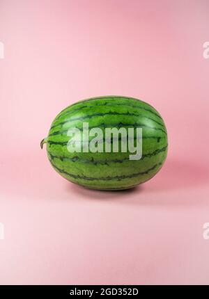 Fresh watermelon on trendy pastel pink background. Minimal tropical fruits and summer concept. Stock Photo