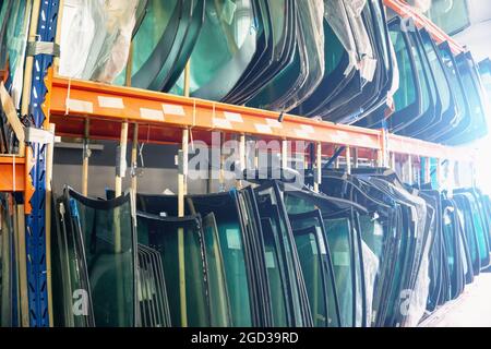 Lots of windshields for different cars on service station shelves ready ...