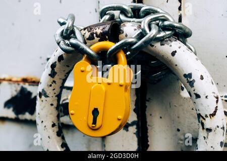 Old locked padlock hanging on chain. Bad security concept. Obsolete security technology Stock Photo