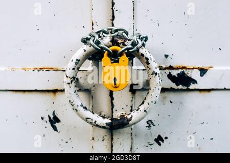 Old locked padlock hanging on chain. Bad security concept. Obsolete security technology Stock Photo
