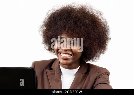 Young black Hispanic Latina business executive woman, with afro hair, smiles drinking coffee in her office on white background Stock Photo