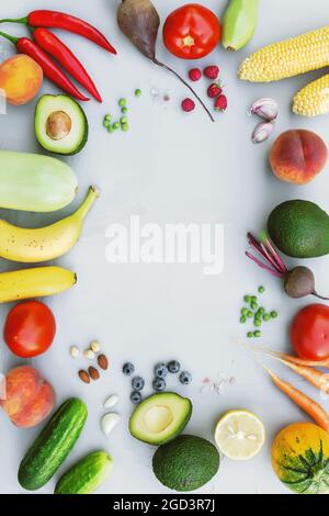 Flat lay with different food, organic vegetables, bio fruits, berries, nuts, spices, herbs. Copy space area for some text. Veggies on grey concrete ba Stock Photo