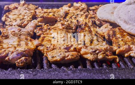 Grilled chicken legs with smoke from the grill coals. BBQ party. Stock Photo