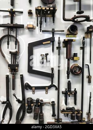 Many tools for repairing motorcycles hanging on wall in workshop. Set Craftsman tool , mechanical tools. Professional mechanic using different tools f Stock Photo