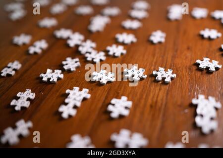 Pieces of jigsaw puzzle on wooden table Stock Photo