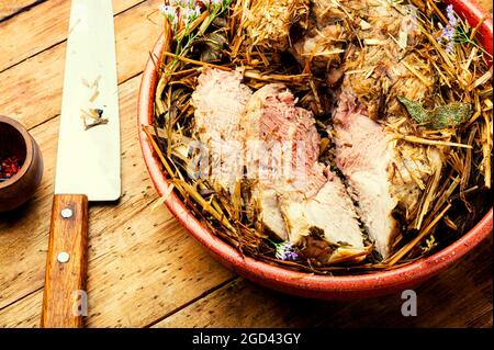 Appetizing meat braised in fresh hay.Roasted pork loin in hays. Stock Photo