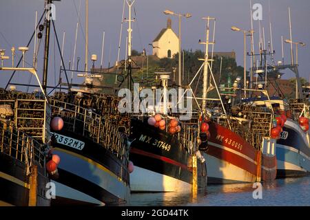 FRANCE, FINISTERE (29), ROSCOFF, BOATS DOCKED IN THE FISHING HARBOR, CHAPEL SAINTE BARBE IN THE BACKGROUND, BRITTANY. Stock Photo