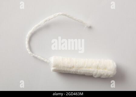 Absorbent protective and absorbent cotton tampon for women's care on white background. Top view. Horizontal composition. Stock Photo