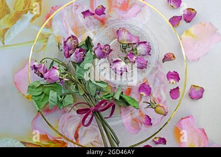 botany, potpourri / dried cerise roses on a glass plate with rose petal photo background, ADDITIONAL-RIGHTS-CLEARANCE-INFO-NOT-AVAILABLE Stock Photo
