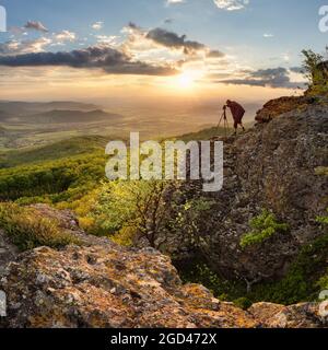 Silouette od photographer in nice mountain sunset with green forest Stock Photo