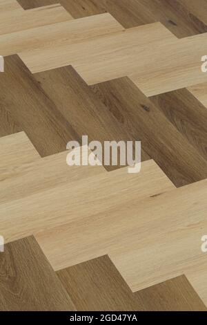 Laminate and parquet with herringbone background. Wooden floor with a chevron pattern in the living room of the designer interior. High quality photo Stock Photo
