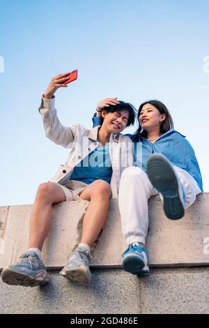 Cute asian couple taking selfie while having breakfast Stock Photo - Alamy