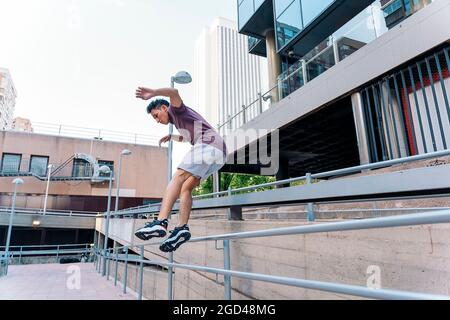 Focused young man practicing parkour tricks in the city and having fun. Stock Photo