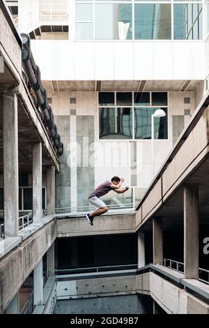 Young handsome man practicing parkour in the city and training. Stock Photo