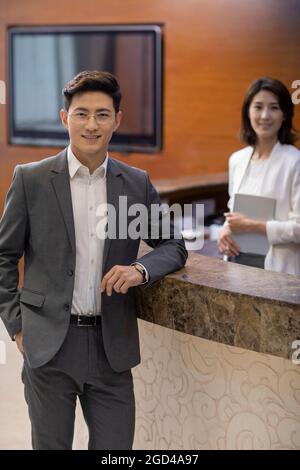 Businessman checking in at front desk Stock Photo