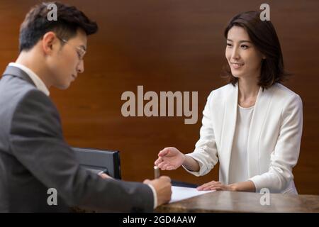 Businessman checking in at front desk Stock Photo