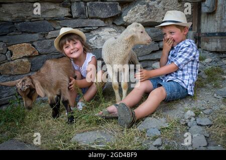 FRANCE, SAVOIE(SAVOY) (73 ) SAINT MARTIN OF BELLEVILLE, CHILD AND LAMBS IN THE FARM OF THE HIGH MOUNTAIN PASTURE OF THE HUNTING Stock Photo
