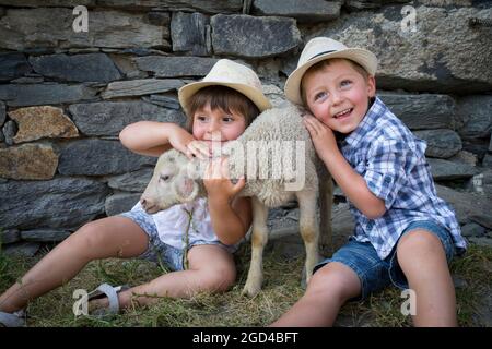 FRANCE, SAVOIE(SAVOY) (73 ) SAINT MARTIN OF BELLEVILLE, CHILD AND LAMBS IN THE FARM OF THE HIGH MOUNTAIN PASTURE OF THE HUNTING Stock Photo