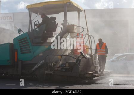 Tula, Russia - May 16, 2021: Process of asphalting, asphalt paver machine during road construction works, working on the new road construction site, p Stock Photo