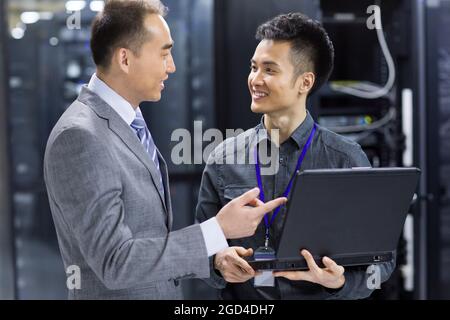 Businessmen talking in computer room Stock Photo