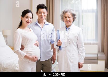 Pregnant woman with husband and doctor Stock Photo