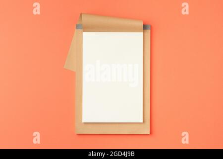 Open notebook on orange background. Stock Photo
