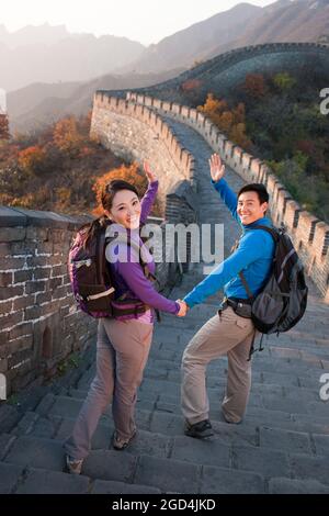Young couple waving on Great Wall Stock Photo
