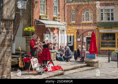 Buskers UK town, view in summer of buskers playing music in Fore Street in Totnes, Devon, England, UK Stock Photo