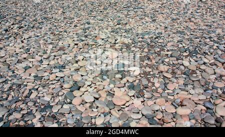 Pebbles On The Beach As Background. Beach Pebble Texture. Abstract Natural Sea Stones Pebble Backdrop. Stock Photo
