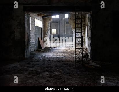 Abandoned industrial interior. Old factory with rubble on floor, broken glass and wooden stairs Stock Photo