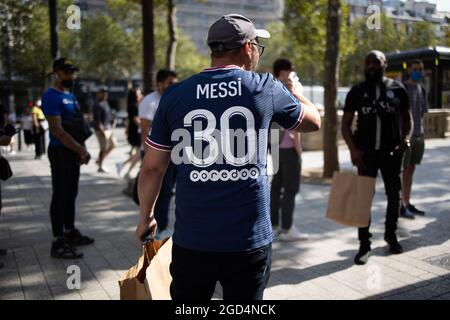 Paris, France. 11th Aug, 2021. A supporter wears a jersey of PSG's Argentinian football player Lionel Messi, that he has just bought at the Paris-Saint-Germain (PSG) football club store on the Champs Elysees avenue in Paris on August 11, 2021. Messi signed on August 10, 2021 a two-year deal with PSG with the option of an additional year. The 34-year-old will wear the number 30 in Paris, the number he had when he began his professional career at Barca. Photo by Raphael Lafargue/ABACAPRESS.COM Credit: Abaca Press/Alamy Live News