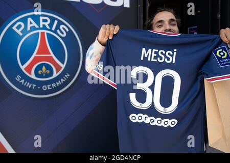 Paris, France. 11th Aug, 2021. A supporter shows a jersey of PSG's Argentinian football player Lionel Messi, that he has just bought at the Paris-Saint-Germain (PSG) football club store on the Champs Elysees avenue in Paris on August 11, 2021. Messi signed on August 10, 2021 a two-year deal with PSG with the option of an additional year. The 34-year-old will wear the number 30 in Paris, the number he had when he began his professional career at Barca. Photo by Raphael Lafargue/ABACAPRESS.COM Credit: Abaca Press/Alamy Live News