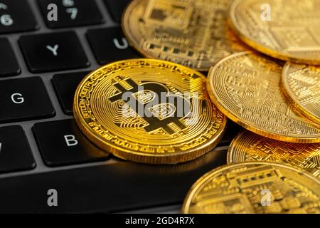 Gold bitcoin coins on laptop keyboard. Stock Photo