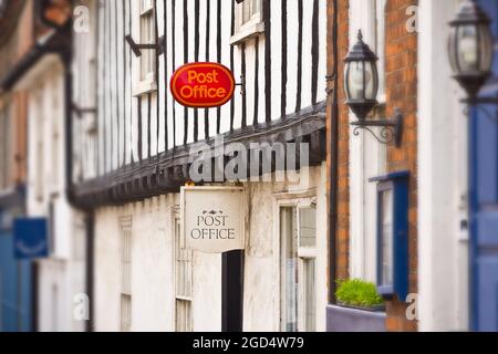Walsingham, Norfolk, England - May 18, 2012: british post office with one red and one white sign in an old half-timbered building. Stock Photo
