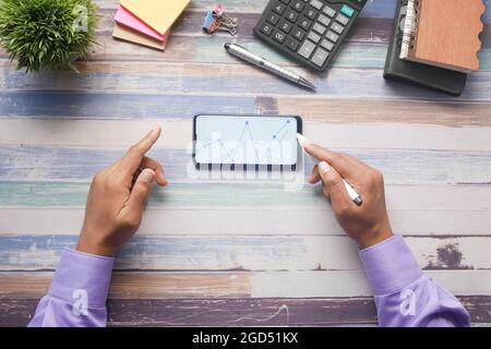 young man analyzing stock chart on smart phone Stock Photo
