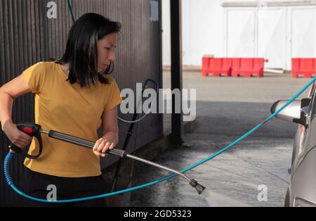 woman washing the car in a car wash Stock Photo