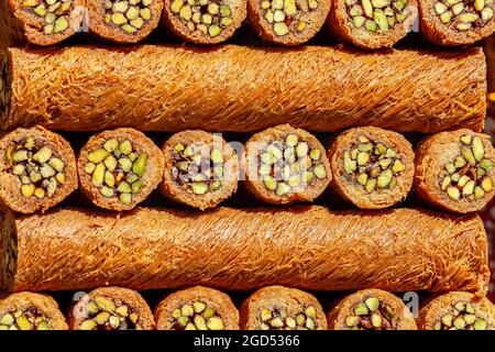 Traditional Turkish sweet called "Burma Kadayif " made with dough wrapped around a pistachios. Stock Photo