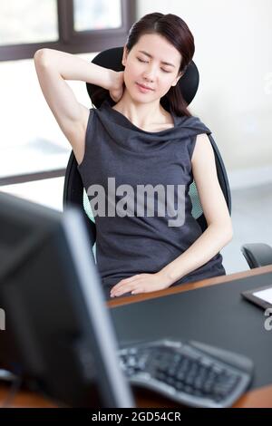 Young office lady massaging neck Stock Photo - Alamy