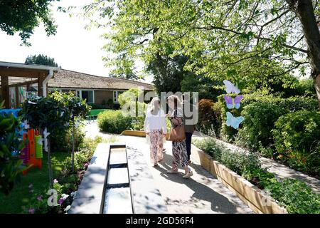 Captain Sir Tom Moore's daughter Hannah Ingram-Moore alongside his grandchildren Benjie Ingram-Moore and Georgia Ingram-Moore during the official opening of a new garden at the Helen and Douglas House children's hospice in Oxford. Picture date: Wednesday August 11, 2021. Stock Photo