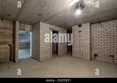 Empty basement room with minimal preparatory repairs. interior with white brick walls Stock Photo