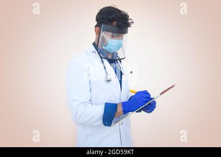 A health worker in Lab Coat Writing a notepad and pen Stock Photo