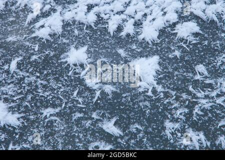 frozen snowflakes - ice abstract textured background. snow paintings on ice surface Stock Photo