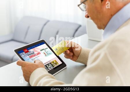 man with laptop with United States Permanent Resident Card website Stock Photo
